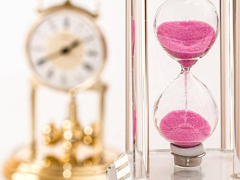 A pink hourglass and a clock